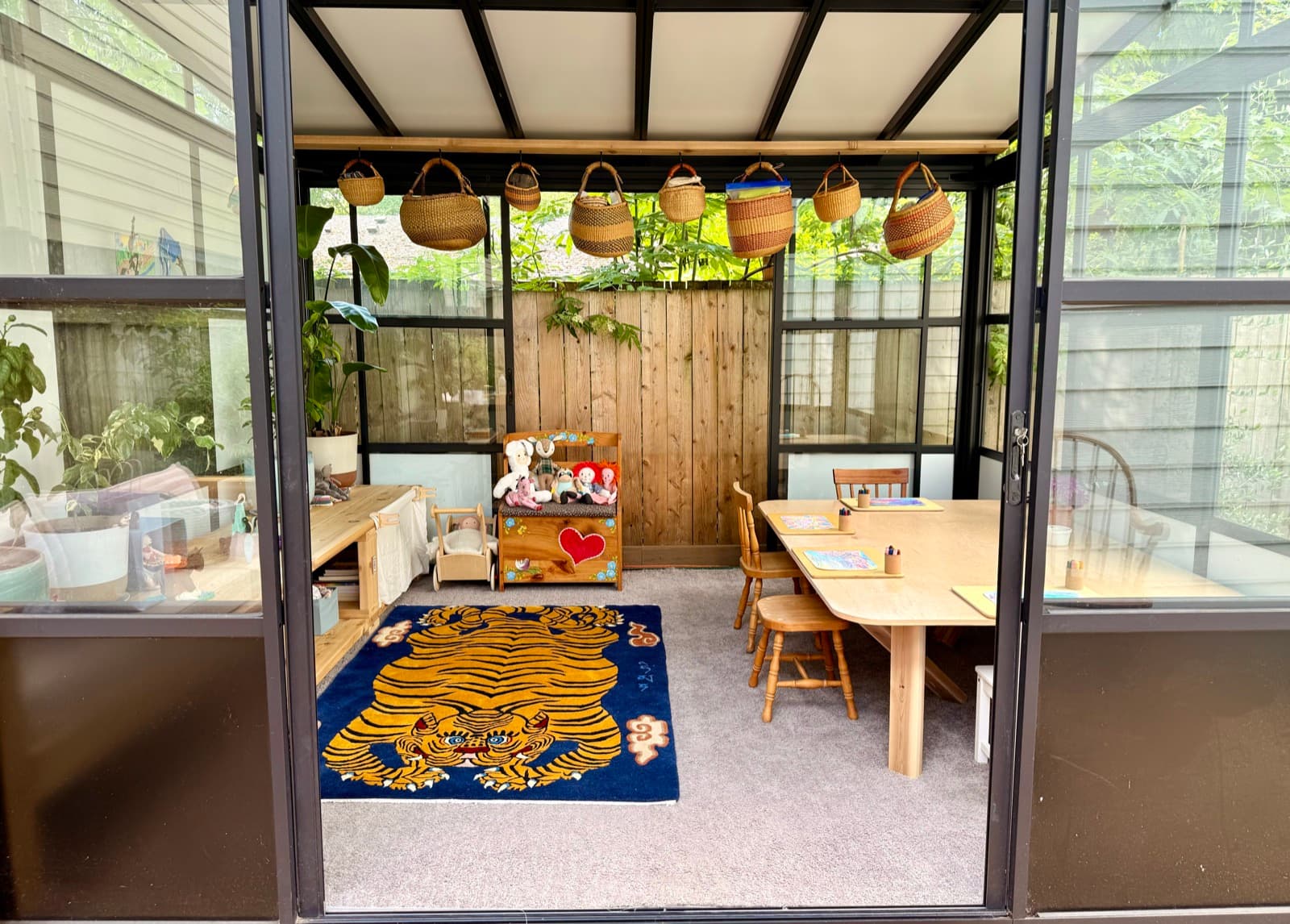 A calm, quiet view into the studio, with baskets hanging and a table set for class